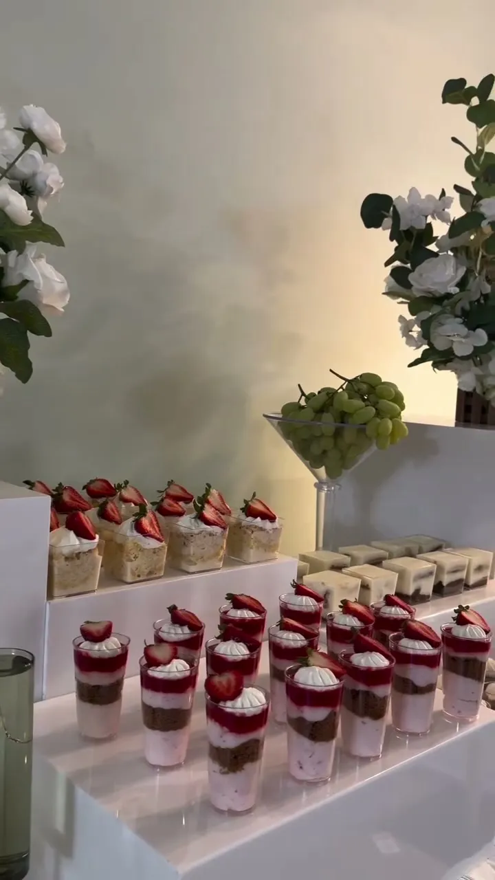Layered tres leches cups on a white dessert table
