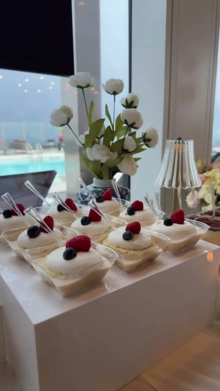 Berry cream cups on white risers by a rooftop pool