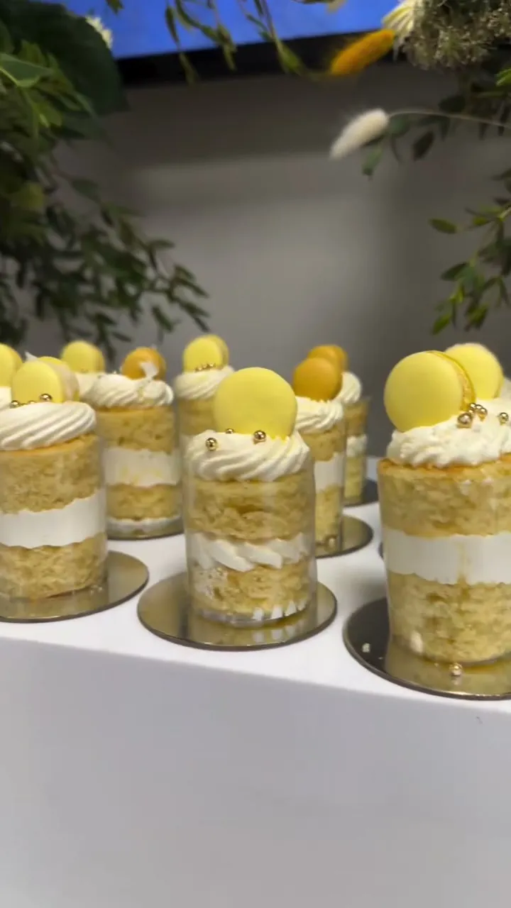 Lemon mini layer cakes with macaron tops at a corporate event