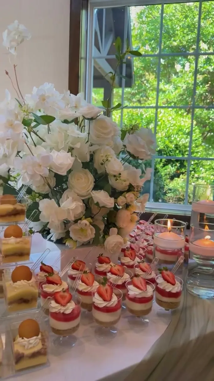 White floral wedding dessert table by a window