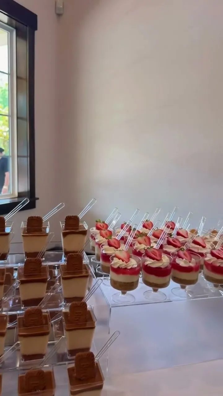 Tiered tiramisu and strawberry cups on a wedding dessert table