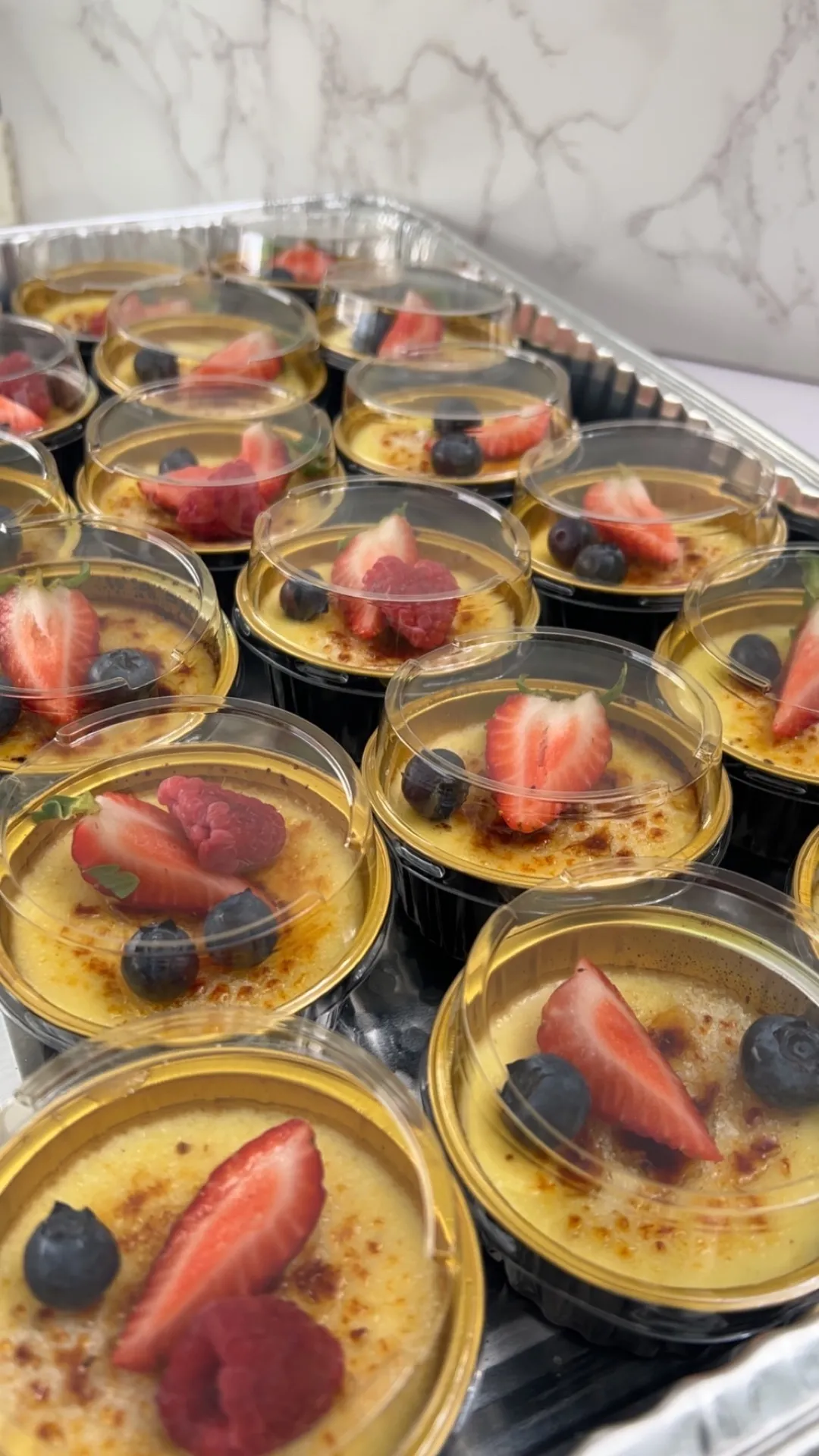 Crème brûlée cups topped with strawberries and blueberries